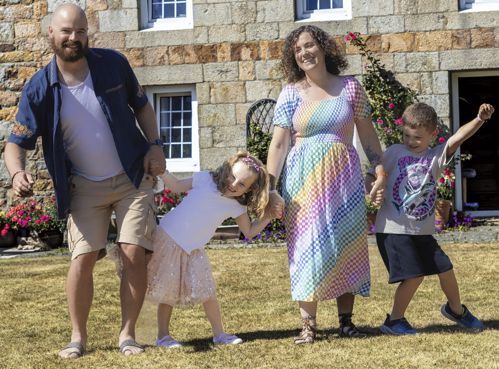 Family of four playing together outside their home